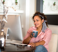 person smiling and doing research on the computer