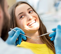 Woman smiles at her Worcester dentist after treatment